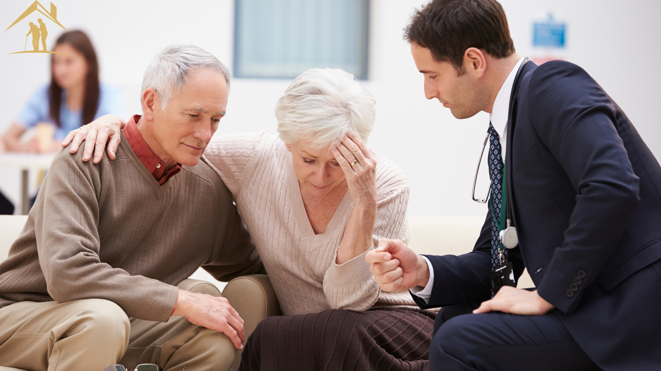 An elderly couple sits with their doctor after a dementia diagnosis, both gazing downward and the woman resting her head in her hand as they take in the news.