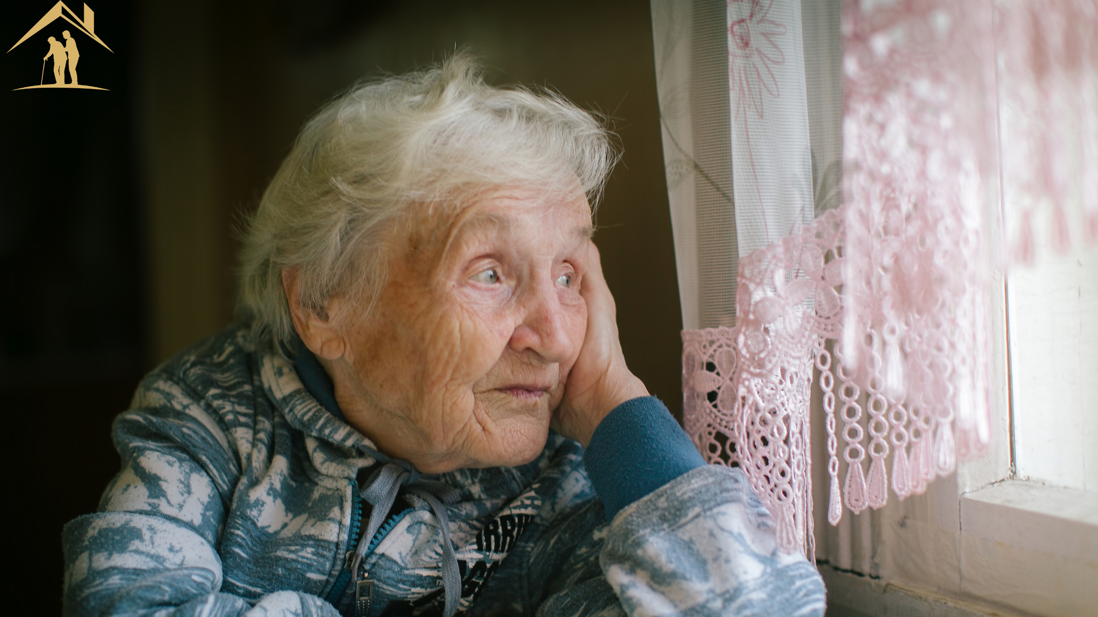 Elderly woman in her eighties gazing out a window, reflecting a family's question of whether her memory changes are normal aging or early dementia.